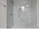 Modern shower featuring white marble tile and a frameless glass enclosure for a clean and luxurious feel at 123 Mills Garden Rd, Statesville, NC 28625