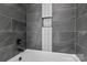 A stylish shower area featuring dark gray tiling and a built-in niche for convenience and modern aesthetic at 123 Mills Garden Rd, Statesville, NC 28625