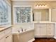 Bathroom featuring soaking tub next to large window and vanity with granite counter at 12403 Panthersville Dr, Charlotte, NC 28269