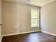 This bedroom has wood flooring and a window providing natural light at 12403 Panthersville Dr, Charlotte, NC 28269