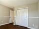 Neutral bedroom featuring wood flooring and white closet doors at 12403 Panthersville Dr, Charlotte, NC 28269