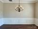 Dining room featuring a modern chandelier, wainscoting, and dark hardwood flooring at 12403 Panthersville Dr, Charlotte, NC 28269