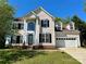 Traditional two-story home with a two-car garage, complemented by a well-manicured front lawn at 12403 Panthersville Dr, Charlotte, NC 28269
