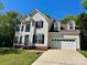 Traditional two-story home with a two-car garage, complemented by a well-manicured front lawn at 12403 Panthersville Dr, Charlotte, NC 28269