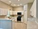 Bright kitchen with white cabinets, stainless steel appliances, and a breakfast bar at 12403 Panthersville Dr, Charlotte, NC 28269