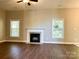 Living room featuring a modern ceiling fan and dark hardwood flooring and a fireplace at 12403 Panthersville Dr, Charlotte, NC 28269