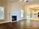 Open-concept living room featuring a fireplace, hardwood floors, and seamless transition to the kitchen at 12403 Panthersville Dr, Charlotte, NC 28269