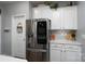 Modern kitchen featuring stainless steel refrigerator, white cabinets, and ample counter space at 126 W Morehouse Ave, Mooresville, NC 28117