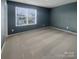 Large bedroom has neutral-toned walls and carpet with a window letting in natural light at 1298 Bryson Ln, Denver, NC 28037