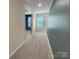 Hallway with neutral walls and carpet leads to a sunlit room with a window at 1298 Bryson Ln, Denver, NC 28037