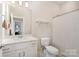 Clean bathroom featuring a white vanity, toilet, shower and a shelf at 14707 Batteliere Dr, Charlotte, NC 28278