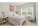 Sunlit bedroom featuring neutral walls, plush carpet, and bright windows at 14707 Batteliere Dr, Charlotte, NC 28278