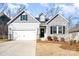 Charming single-Gathering home featuring a mix of stone and siding, a two-car garage, and a well-manicured lawn at 14707 Batteliere Dr, Charlotte, NC 28278