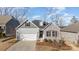 Charming single-Gathering home featuring a mix of stone and siding, a two-car garage, and a well-manicured lawn at 14707 Batteliere Dr, Charlotte, NC 28278