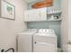 Laundry room with white cabinets, shelves, and modern washer and dryer units at 14707 Batteliere Dr, Charlotte, NC 28278