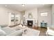 Bright living room featuring a fireplace, hardwood floors, and large windows, perfect for relaxing or entertaining guests at 14707 Batteliere Dr, Charlotte, NC 28278