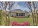 Large backyard with a screened deck, lush green grass, and mature trees at 14830 Creeks Edge Dr, Charlotte, NC 28278