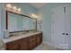 Bathroom featuring double sinks, a granite countertop and large framed mirror at 14830 Creeks Edge Dr, Charlotte, NC 28278