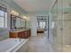 Bright bathroom featuring a soaking tub, walk-in shower, and double sink vanity at 14830 Creeks Edge Dr, Charlotte, NC 28278