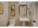 Powder room with pedestal sink, toilet and attractive wallpaper at 14830 Creeks Edge Dr, Charlotte, NC 28278