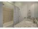 Well-lit bathroom with granite countertops, shower-tub combo, and neutral tile at 14830 Creeks Edge Dr, Charlotte, NC 28278