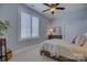 Cozy bedroom featuring plantation shutters, ceiling fan and warm, neutral decor at 14830 Creeks Edge Dr, Charlotte, NC 28278