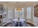 Bright breakfast nook with modern lighting, round table, and large windows with shutter blinds at 14830 Creeks Edge Dr, Charlotte, NC 28278