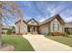 Charming stone home with manicured lawn and long driveway leading to attached two car garage at 14830 Creeks Edge Dr, Charlotte, NC 28278