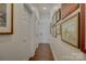 Hallway featuring wood floors, white trim and doors and artwork at 14830 Creeks Edge Dr, Charlotte, NC 28278