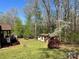 Expansive backyard features a charming shed, lush greenery, and mature trees, ideal for serene outdoor enjoyment at 1496 Givens St, Hickory, NC 28602