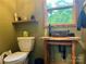 Rustic bathroom featuring a unique stone sink and wooden accents and a window looking out to lush green trees at 1496 Givens St, Hickory, NC 28602