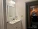 White vanity bathroom with a gray countertop and mirror with views of a living space at 1496 Givens St, Hickory, NC 28602