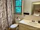 Bright bathroom featuring a marble-patterned shower curtain and a vanity with a white countertop and framed mirror at 1496 Givens St, Hickory, NC 28602
