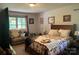 Cozy bedroom with a decorative quilt and a sitting area near a bright window at 1496 Givens St, Hickory, NC 28602