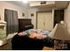 Cozy bedroom featuring a vintage piano, double door closet, and comfortable floral bedding, ideal for relaxation at 1496 Givens St, Hickory, NC 28602