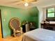 Cozy bedroom features hardwood floors, a large wicker chair, and ample lighting, creating a warm and inviting space at 1496 Givens St, Hickory, NC 28602