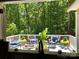 Well-appointed covered deck featuring comfortable seating and a picturesque view of the lush surrounding forest at 1496 Givens St, Hickory, NC 28602