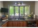 A kitchen sink below a large window looks out to the trees at 1496 Givens St, Hickory, NC 28602