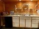 Basement kitchenette with wood paneling, glass shelving, and sleek white cabinetry at 1496 Givens St, Hickory, NC 28602