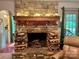 Living room featuring a stone fireplace with wood storage on either side and a comfortable leather chair at 1496 Givens St, Hickory, NC 28602