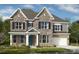 Two-story stone home with a covered porch, well-manicured lawn, and attached two-car garage at 3009 Tramore Dr, Harrisburg, NC 28075