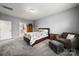 Comfortable bedroom featuring carpet, a large bed, and a glimpse into an ensuite bathroom at 3019 Foggy Hollow Ln, Clover, SC 29710
