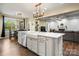 Open concept kitchen with white cabinets, farmhouse sink, and views to living and dining areas at 3019 Foggy Hollow Ln, Clover, SC 29710