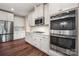 Bright kitchen showcasing stainless steel appliances, white cabinets, and dark hardwood flooring at 3019 Foggy Hollow Ln, Clover, SC 29710