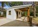 Back exterior featuring white siding and a wooden patio with a view of the wooded yard at 4913 Seacroft Rd, Charlotte, NC 28210
