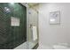 Modern bathroom featuring a tiled shower with a glass door, herringbone tile, and gold fixtures at 4913 Seacroft Rd, Charlotte, NC 28210