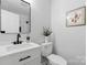 Updated bathroom featuring a sleek sink, toilet, and modern black fixtures at 4913 Seacroft Rd, Charlotte, NC 28210