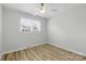 Sun-filled bedroom featuring modern floors, ceiling fan, fresh paint and two windows at 4913 Seacroft Rd, Charlotte, NC 28210