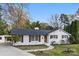 Charming white brick home boasts decorative shutters, and lush landscaping at 4913 Seacroft Rd, Charlotte, NC 28210