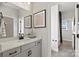 Light-filled bathroom featuring a modern vanity with a black faucet, and a doorway to a full shower at 5009 Duval Cir, Tega Cay, SC 29708